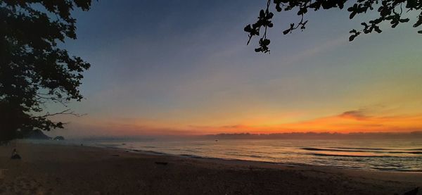 Scenic view of beach against sky during sunset