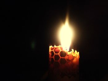 Close-up of lit candle in dark room