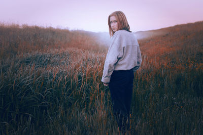Full length of young woman standing on field