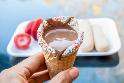 Cropped hand holding ice cream cone