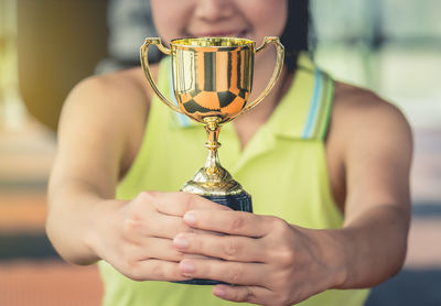 Midsection of woman holding trophy