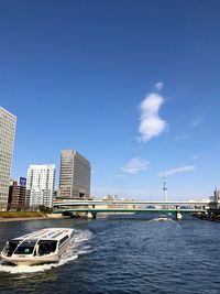 Boats in sea against buildings in city