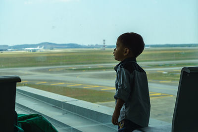 Side view of boy standing at airport