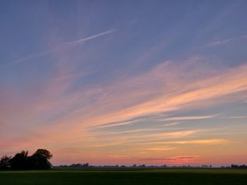 Scenic view of field against sky during sunset