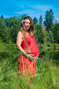 Young woman smiling while standing on field