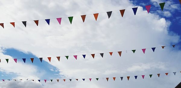 Low angle view of buntings against cloudy sky