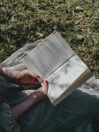 High angle view of man reading book on field