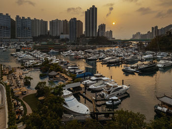 High angle view of marina and buildings against sky during sunset