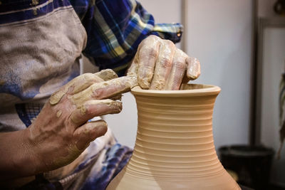 The potter molds clay jug pot closeup. workshop on sculpt white clay closeup. dirty hands in clay. 