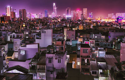 Illuminated cityscape against sky at night