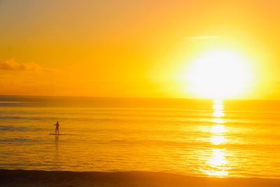 Scenic view of sea against orange sky