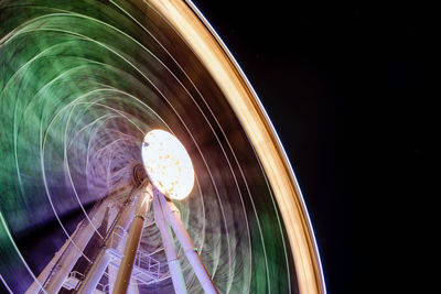 Low angle view of illuminated ferris wheel against clear sky at night