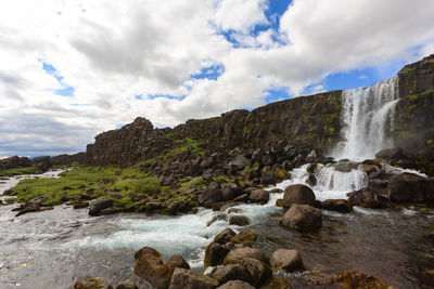 Scenic view of waterfall against sky