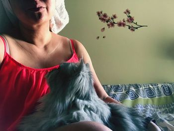 Midsection of woman with dog at home