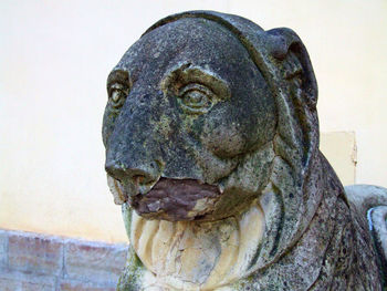 Close-up of old statue against wall