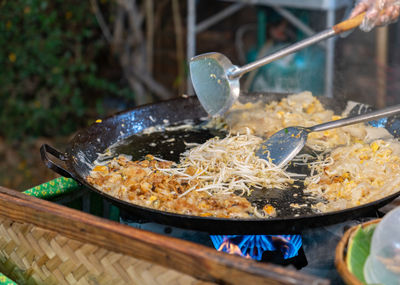 Chef cooking fried clams in big pan, thai food, street food