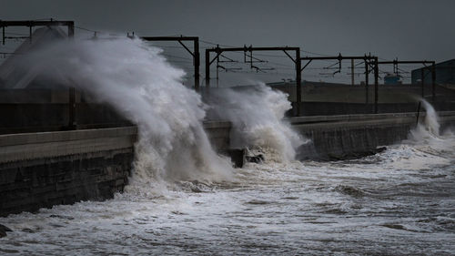 Water splashing in sea against clear sky