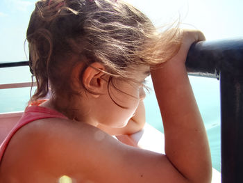 Close-up of girl looking away by railing