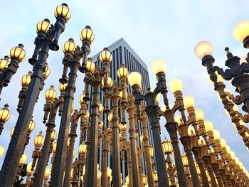 Low angle view of illuminated lamp posts against sky