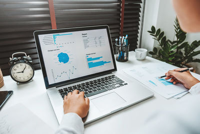 Midsection of man using laptop on table