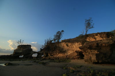 Rock formations on landscape against clear blue sky