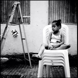 Full length of woman sitting on bench