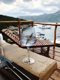 Wineglass on table against sea