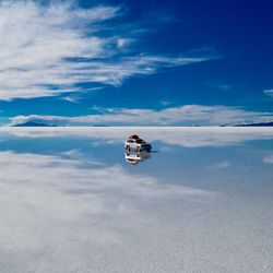 Man on snow covered land against sky