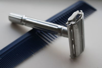 Close-up of razor and comb on table