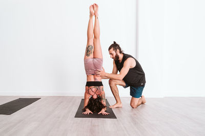 Side view of man instructing woman during yoga