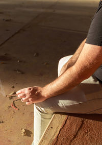 Midsection of man working on wood