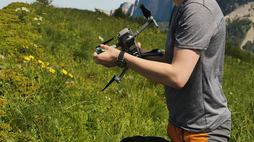 A man holds a quadrocopter in his hands, preparing it for flight. launching a drone on a mountain 