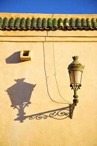 Low angle view of street light against building wall