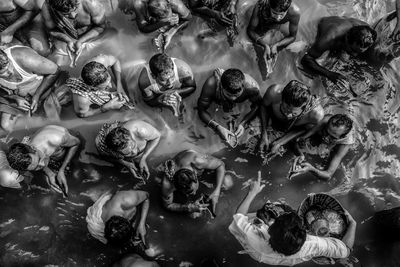 High angle view of people performing religious event in river