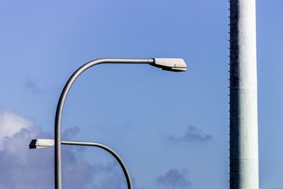 Low angle view of street light against blue sky