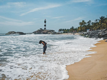 Woman standing on beach against sky