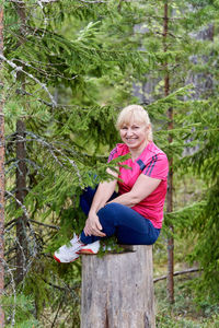 Full length of a smiling young woman sitting outdoors