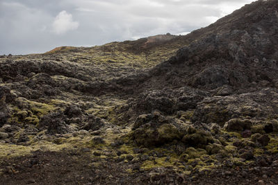 Scenic view of mountain slope against cloudy sky