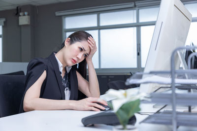 Businesswoman using laptop while sitting on table