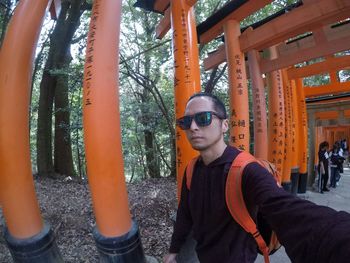 Portrait of young man wearing sunglasses standing outdoors