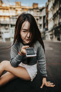 Young woman using mobile phone in city