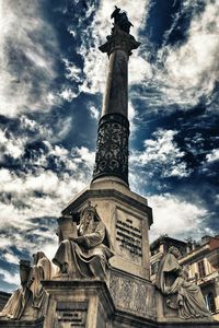 Low angle view of monument against cloudy sky