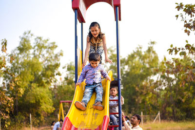 Side view of woman sitting on swing