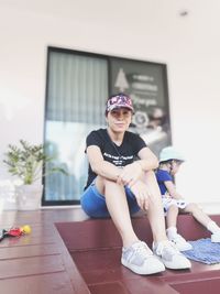 Portrait of a smiling woman sitting against wall