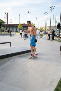 Full length of shirtless man skateboarding
