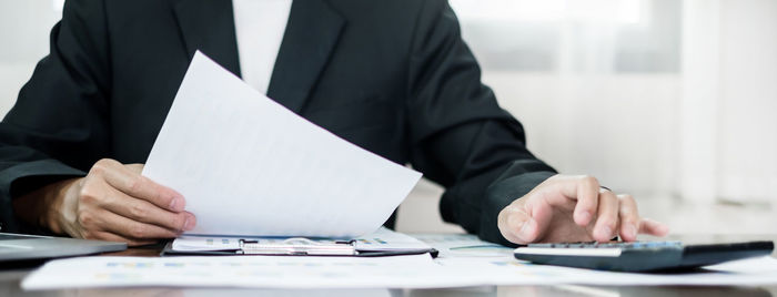 Midsection of businessman working at office