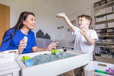 Mother and daughter playing with toys at home