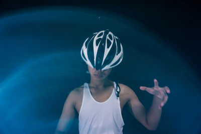 Woman wearing helmet against colored background