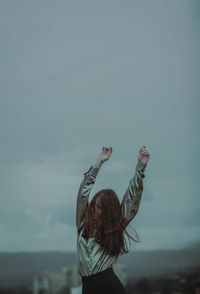 Rear view of woman standing against the sky