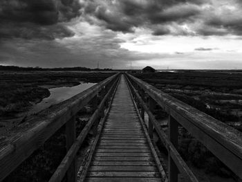 Railroad track against cloudy sky